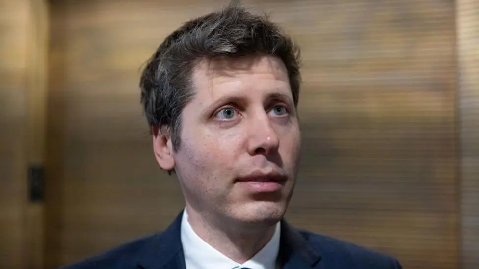 OpenAI chief Sam Altman answering questions in a hallway during a trip to Washington DC.
