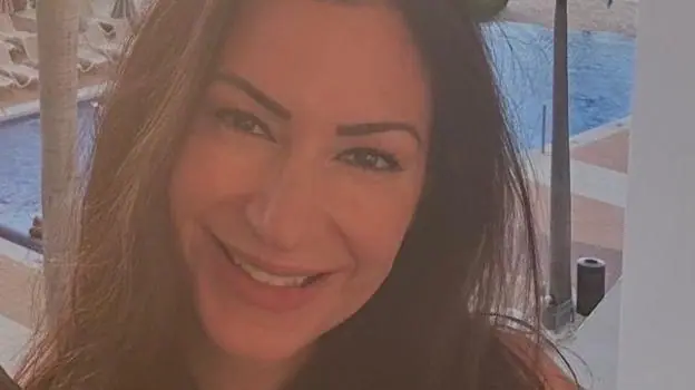 Andria Rose is seen with a swimming pool behind her