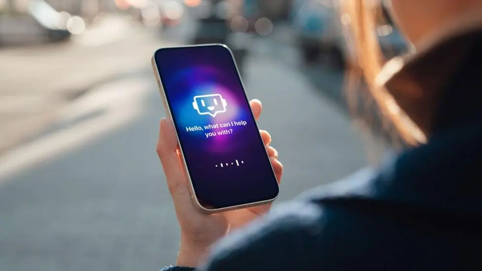 A woman holds a phone with a generic AI interface on the screen which says "hello what can I help you with?"