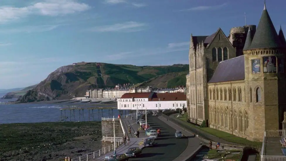 A general view of Old College, a tall brick building overlooking a bay.