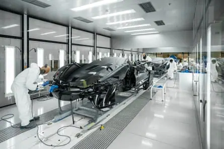 People working on a row of sports cars
