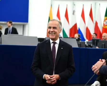 Mark Carney stood at the front of the parliament hemicycle hall