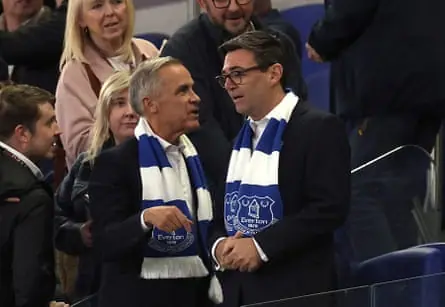 Mark Carney and Andy Burnham wearing Everton scarves at a football match