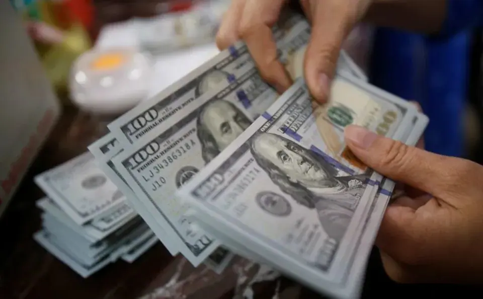An employee of a bank counts US dollar notes at a branch in Hanoi, Vietnam May 16, 2016. REUTERS/Kham · Reuters