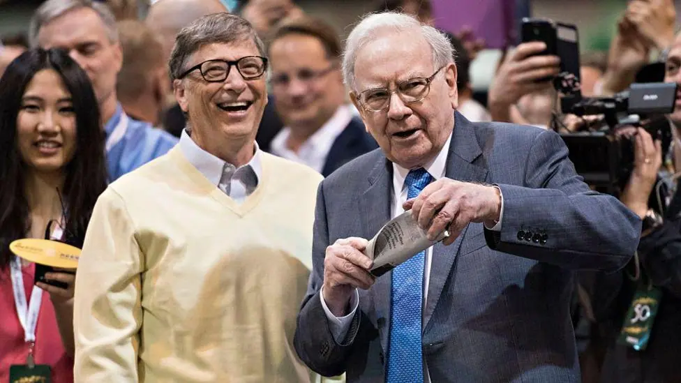 Warren Buffett, Berkshire Hathaway Inc. chairman, right, talks with Bill Gates, billionaire and co-chair of the Bill and Melinda Gates Foundation, as they tour the exhibition floor during the…