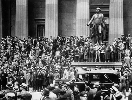 After the news of the Wall Street crash, a crowd of speculators, worried about the fall of their financial securities, have gathered in front of the New York Stock Exchange near where a statue of…