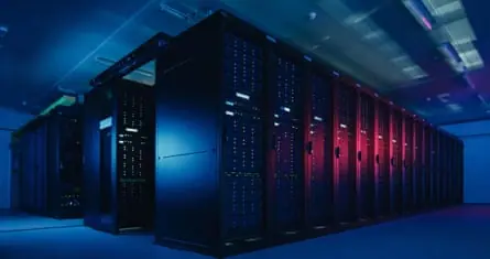 A datacentre with multiple rows of fully operational server racks.