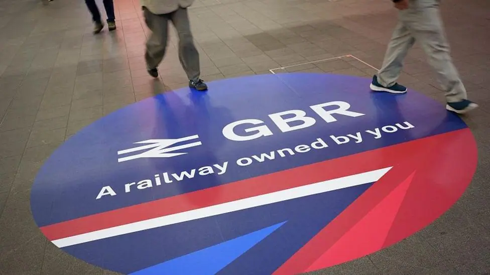 Members of the public walk past the new signage of the Great British Railways (GBR) at London Bridge mainline station, on 9th December 2025, in London, England. The sign is mainly blue with red and…