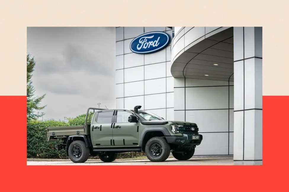 A variant of Ford's Ranger, built for military duty, sits outside the entrance to Ford's Dangenham plant underneath the company's logo.