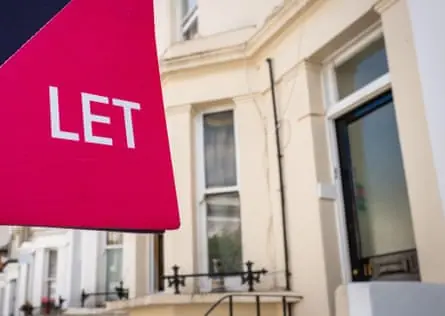 A sign saying 'Let' in front of a row of terrace houses.