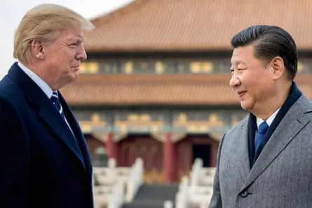 Two men facing each other and smiling tightly.