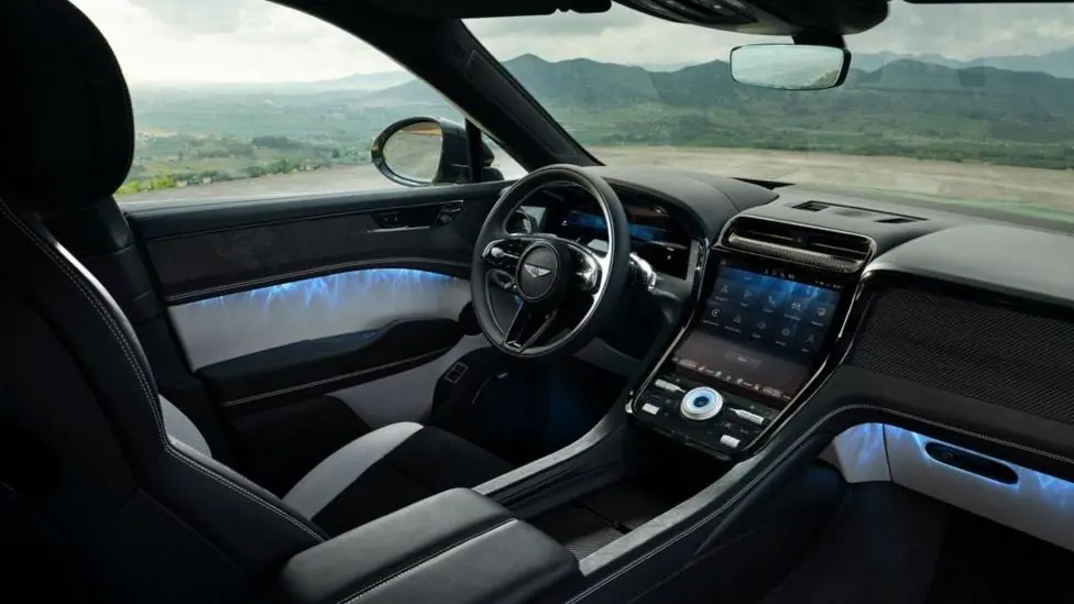 A black and silver car interior with views of countryside seen through the windows.