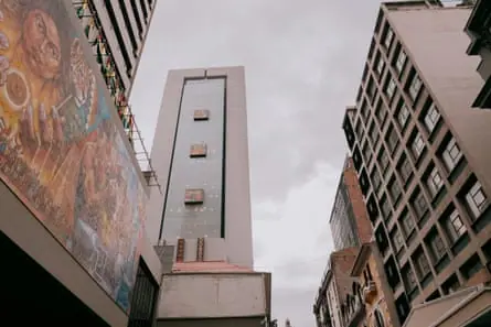 A high-rise building in La Paz Bolivia, photographed from the street level looking up against a grey sky