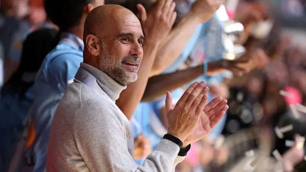 Manager Pep Guardiola applauds as his Manchester City players lift the FA Cup trophy after beating Chelsea in the 2026 final