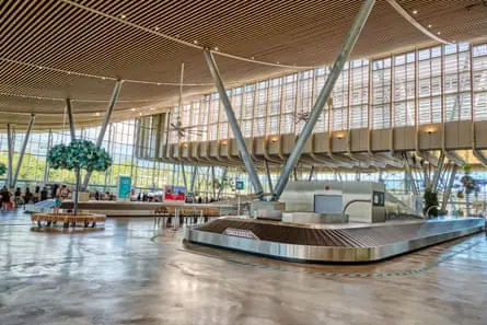 Interior of arrivals hall, with fans above luggage belts