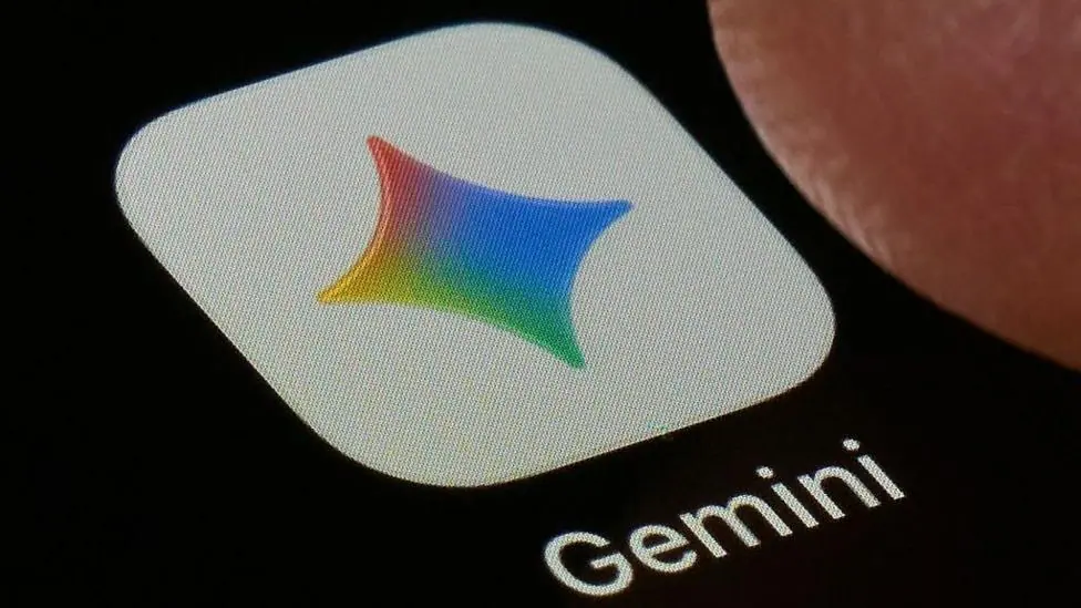 A close-up shot of the Gemini application on a black screen. The icon is a white square with a four-point star in Google's colours, under which the word 'Gemini' is printed.