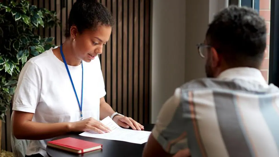 A young woman in a modern office at a table with a co-worker