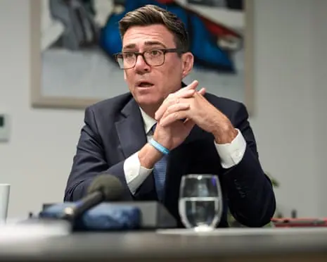 Burnham speaking at desk with glass of water in front of him