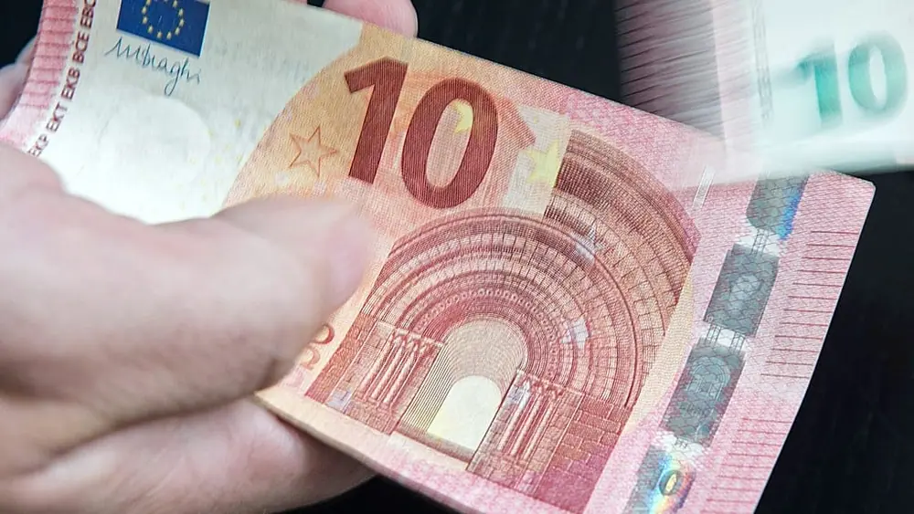 In this picture taken with a long time exposure a counterfeit money expert of the German Federal Bank enumerates new ten euro banknotes during a press conference at the branch