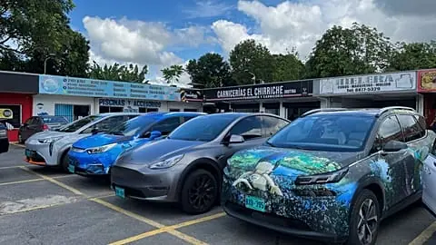 File - Handout photo provided by the Norwegian EV Association showing electric cars parked outside shops.