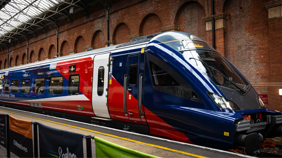 A new train stationed at Marylebone station in London. It is red, blue and white.