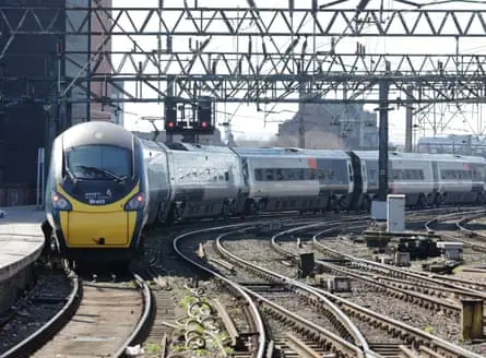 A train curves around the track as it approaches the station platform