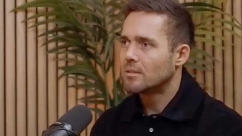 Spencer Matthews sitting in front of a microphone as if speaking on a podcast.