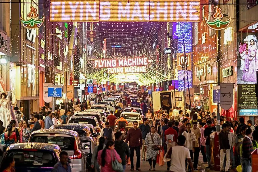 Shoppers gather at the illuminated Commercial Street on the eve of Diwali, the Hindu festival of lights, in Bengaluru on 19 October 2025.