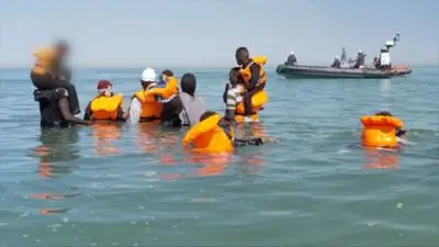 Group of people in the sea, some wearing life jackets