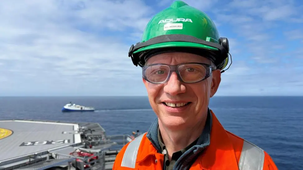 Adura CEO Neil McCulloch on an oil platform with the North Sea in the background