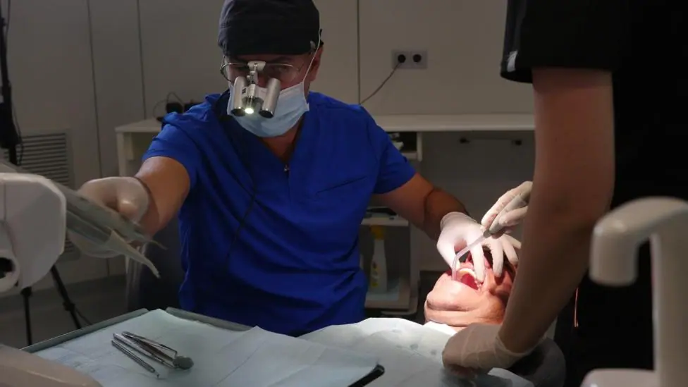 A dentist in Tirana works on Anthony Hook's teeth
