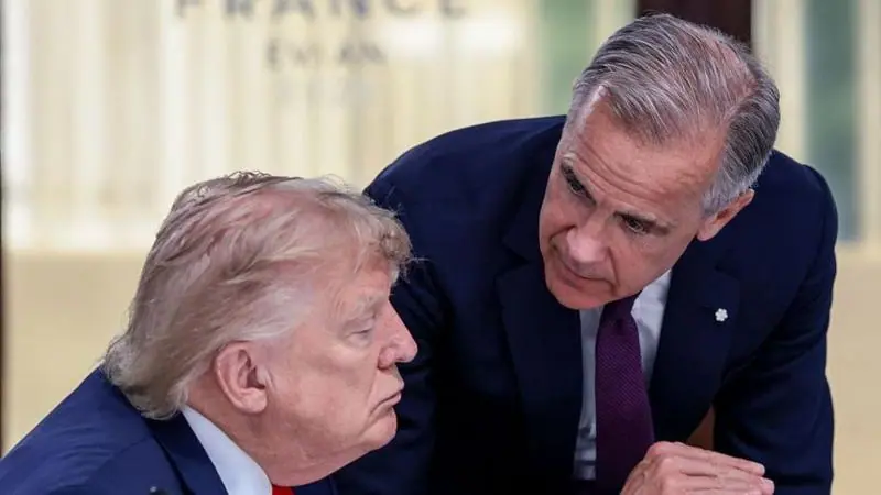 US President Donald Trump (left) speaks with Canada's Prime Minister Mark Carney during a work lunch as part of the G7 summit, in Evian, eastern France, on June 16, 2026. Trump is sitting down while…