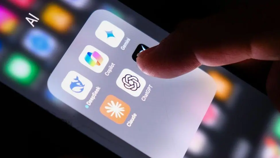 A hand on a phone displaying several AI apps including ChatGPT, Claude, Copilot, DeepSeek and Gemini