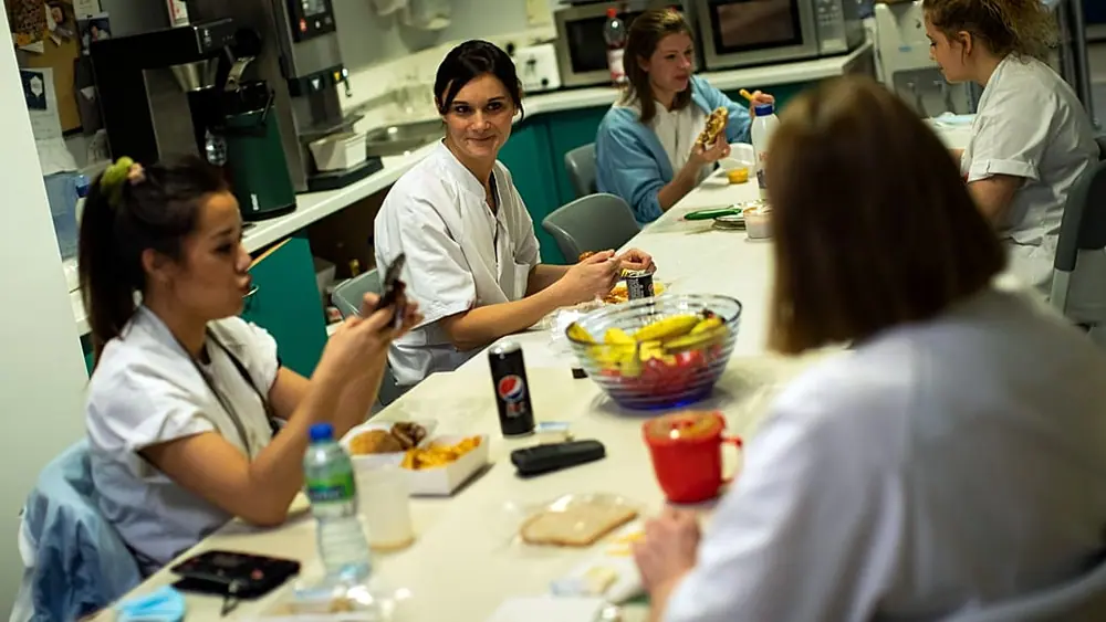 In this Wednesday, Dec. 16, 2020 file photo, Nurse Anne-Catherine Charlier, center, talks to colleagues during a dinner break in the intensive care ward for COVID-19 patients