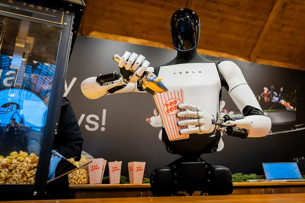 FILE. Tesla's humanoid robot Optimus distributes popcorn at a Christmas market stall during its presentation at a mall in Berlin, Germany, 20 Dec. 2025