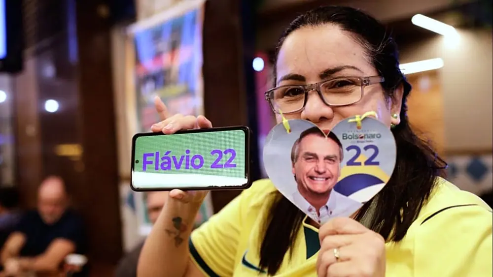 A supporter of opposition presidential candidate Sen. Flavio Bolsonaro poses for a picture as she waits for election results in Rio de Janeiro, Sunday, Oct. 4, 2026