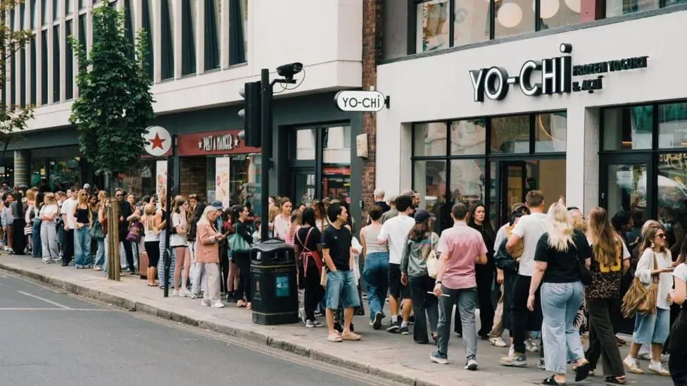 A line of people queueing for frozen yoghurt outside Yo-Chi in central London