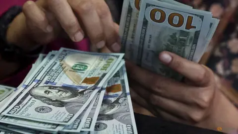 Dollar holds losses as markets await Fed minutes, speakers