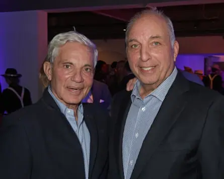 David Reuben and his brother Simon, both in dark suits and light grey shirts, are photographed at the opening night of a theatre production