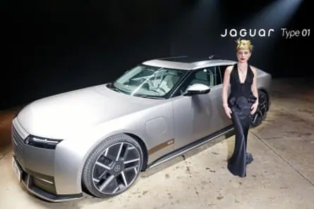 Florence Pugh standing next to a Jaguar Type 01.