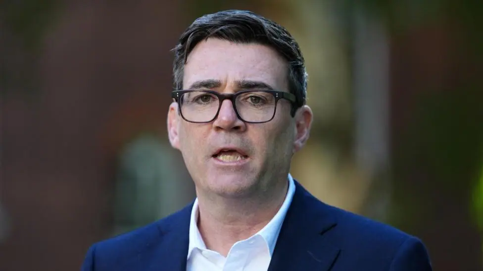 Andy Burnham wearing a navy suit and a white shirt.