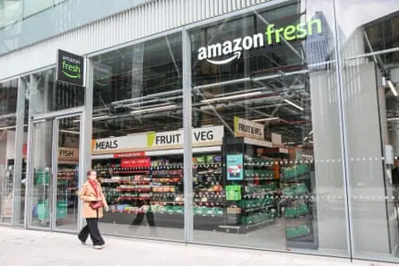A woman passes an Amazon Fresh store
