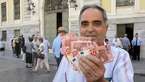 File - Pensioner Giorgos Petropoulos shows ten euros notes who receive from National Bank of Greece in Athens, Wednesday, 1 2015.