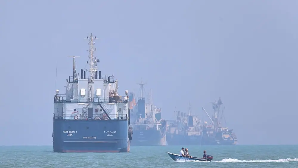 FILE: A small motorboat passes anchored vessels in the Strait of Hormuz off Bandar Abbas, Iran, 11 June 2026