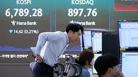 File - Traders watch monitors near a screen showing the KOSPI at the foreign exchange dealing room of the Hana Bank headquarters in Seoul, Thursday, 8 Oct. 2026.