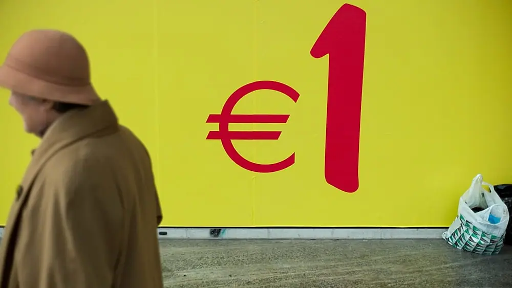 A woman walks past a supermarket in Lisbon, Portugal.