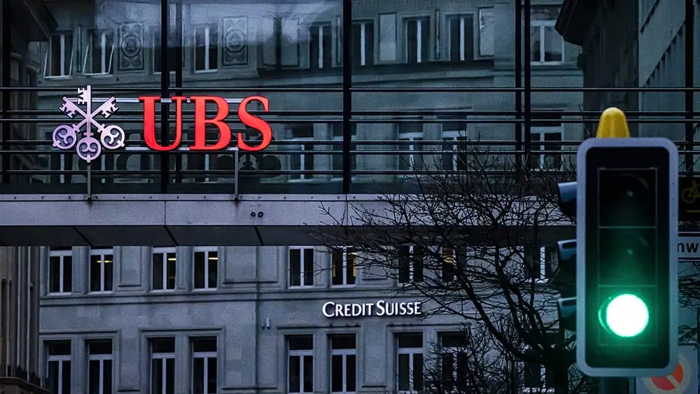 FILE. A traffic light signals green in front of the logos of the Swiss banks Credit Suisse and UBS in Zurich, Switzerland, 19 March 2023