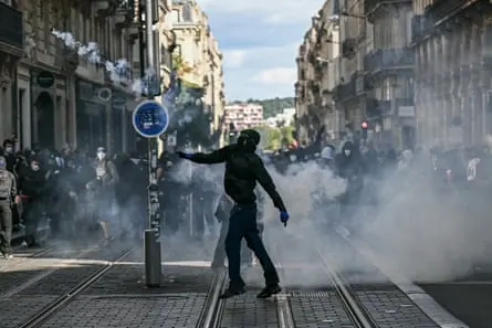 A protester throws a teargas canister fired by police during a demonstration of high-school students in Bordeaux.