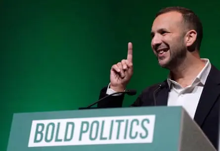 Zack Polanski at the party conference in Bournemouth at a podium with the sign ‘bold politics’