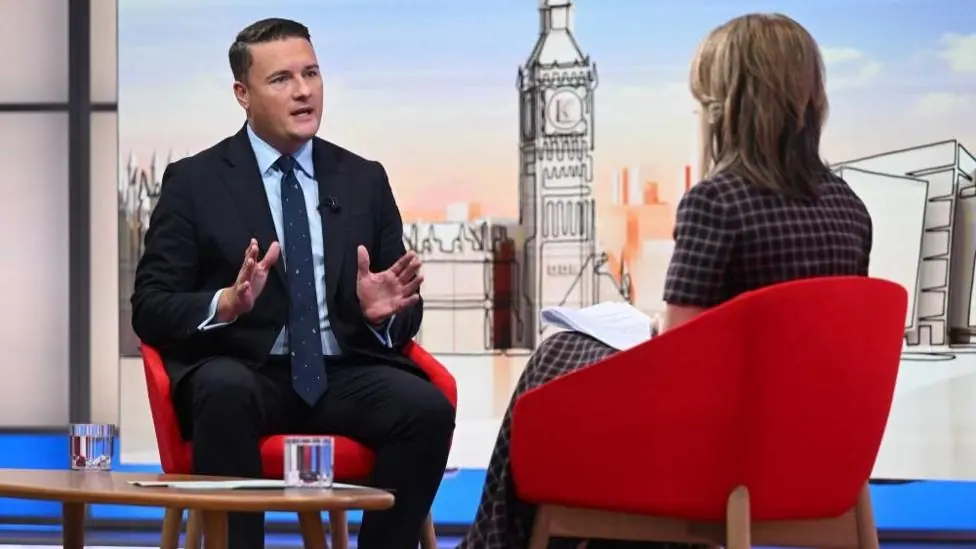 Wes Streeting in the Sunday with Laura Kuenssberg studio. He is wearing a dark navy suit and navy tie with a light blue shirt.